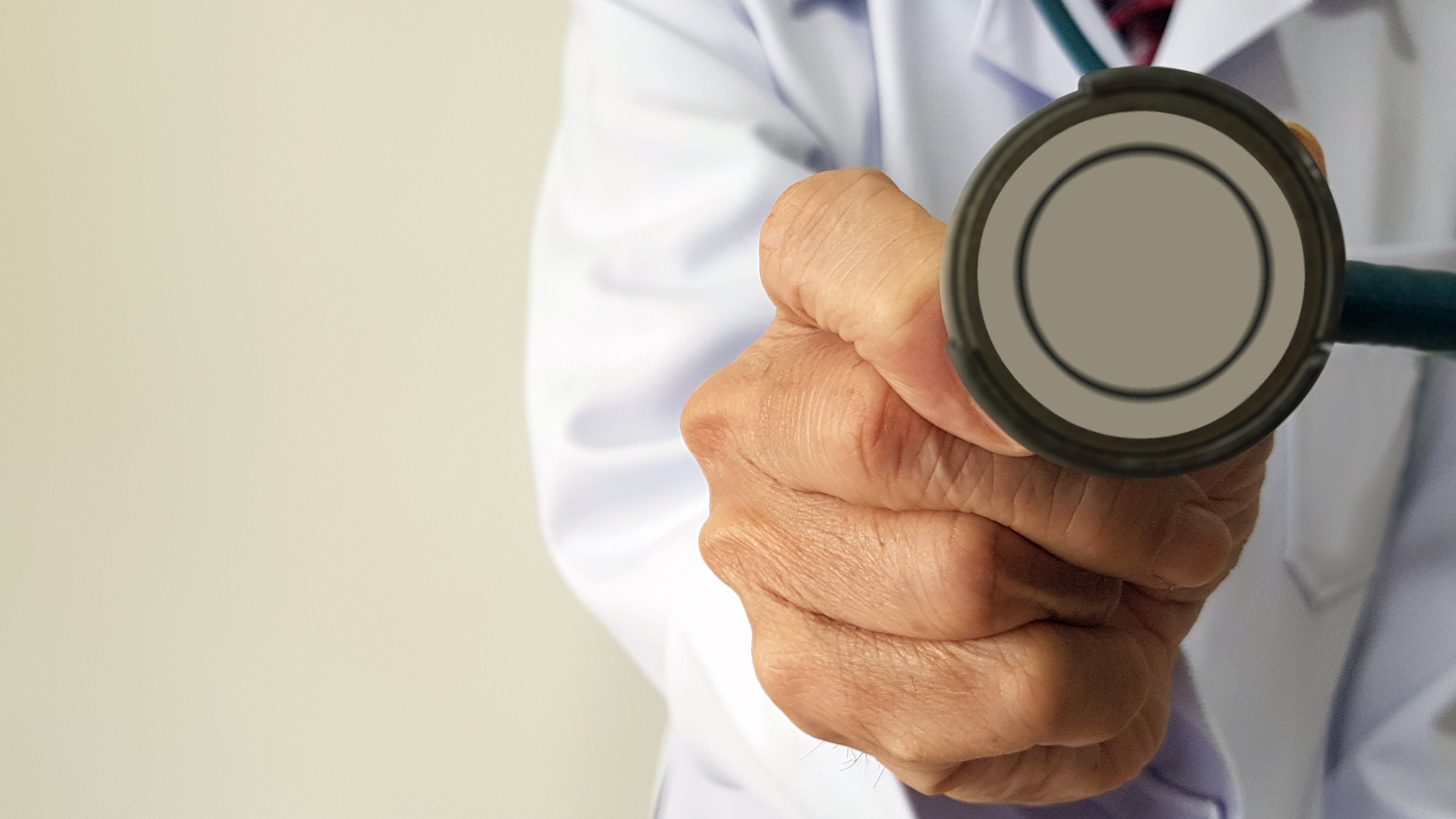 Doctor with extended hand holding a stethoscope